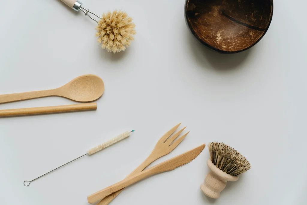 Couverts et ustensiles de cuisine en bambou disposés sur une surface en bois.