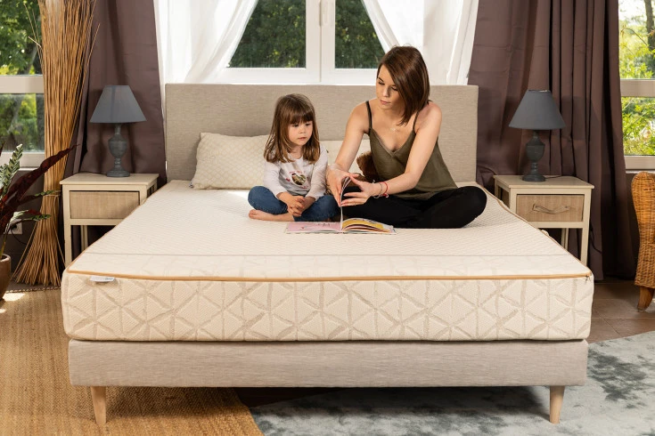 Matelas écologiques dans une chambre avec une mère et sa fille s'amusant ensemble sur le lit.